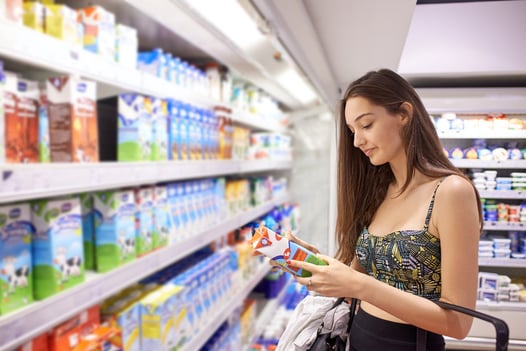 young woman shopping for fruits and vegetables in produce department of a grocery store supermarket